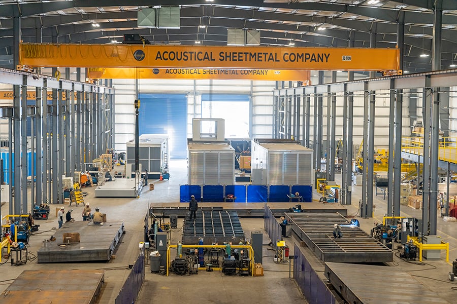 The inside of the Acoustical Sheetmetal Company warehouse with enclosures being produced.